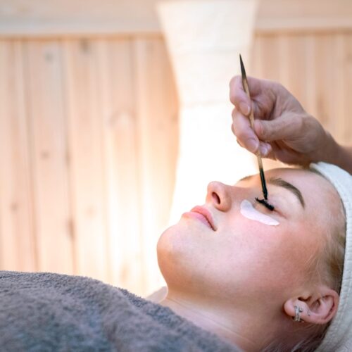 Beauty treatment with lash colouring at salon, person lying relaxed with eye patches
