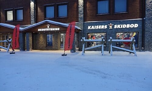 Kaisers Skidbod med skiduthyrning, skyltfönster och snötäckt område utanför.