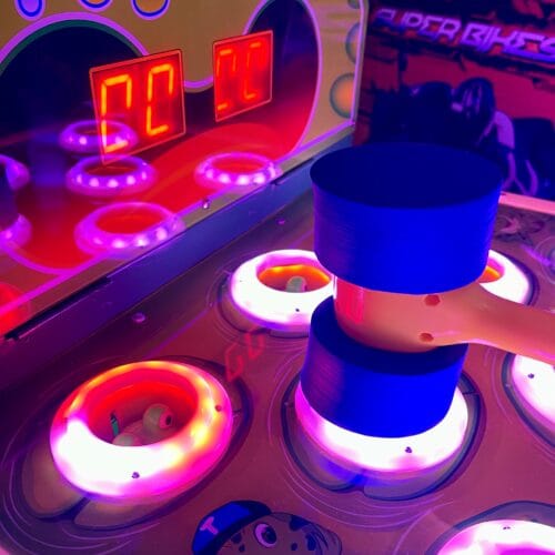 Arkadspel med blinkande ljus och en blå hammare.