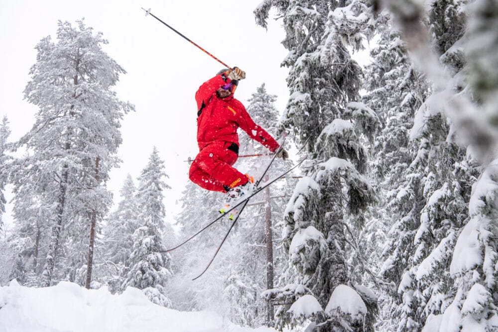 Ski instructors skiing in a snow-covered forest.