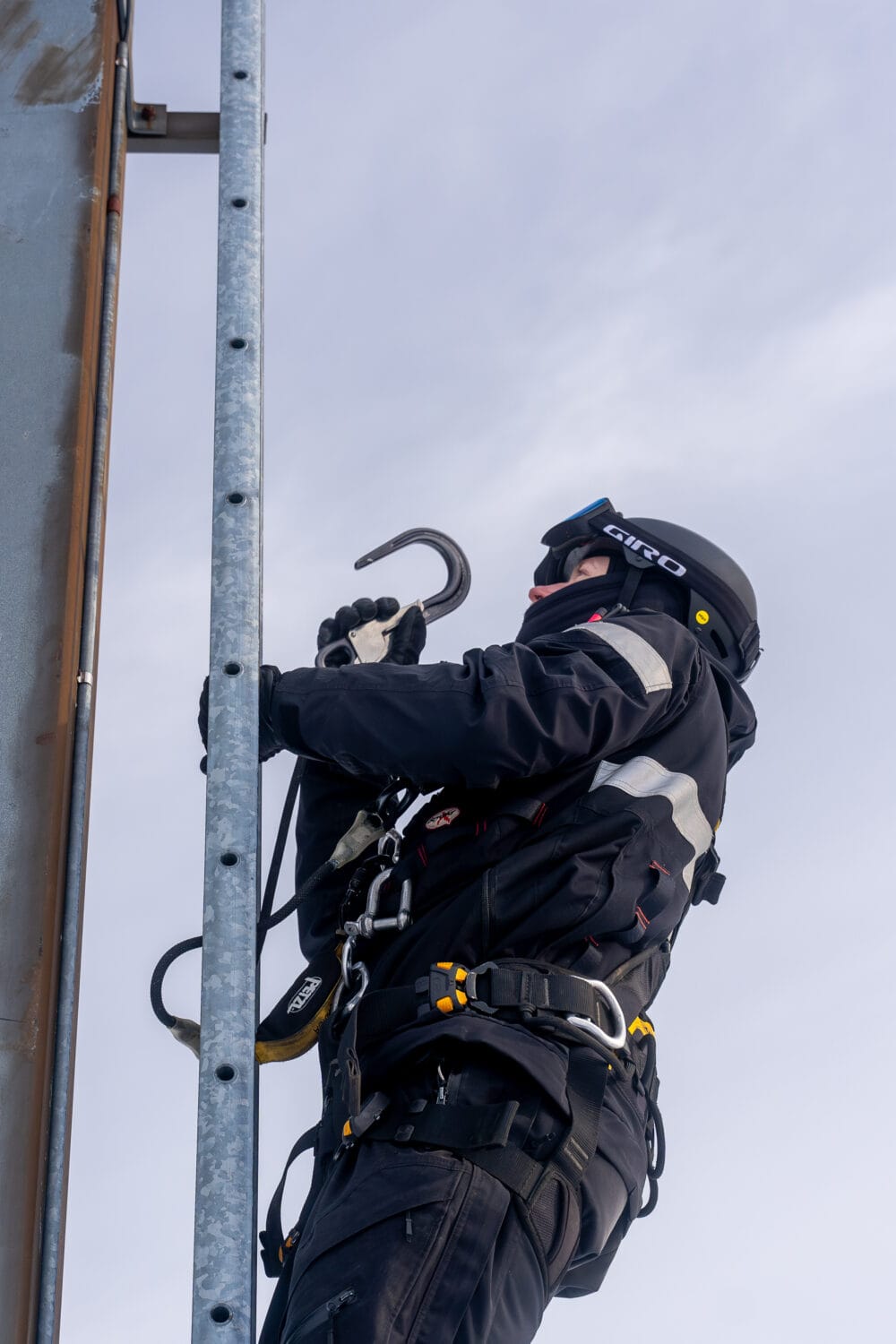 Mechanics climbing a lift mast.